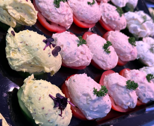 Gefüllte Paprikaschoten mit verschiedenen Aufstrichen, garniert mit Kräutern.